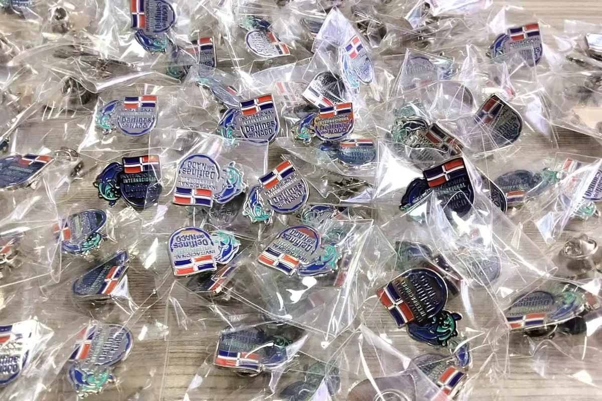 A batch of small pins individually packed in clear plastic bags.
