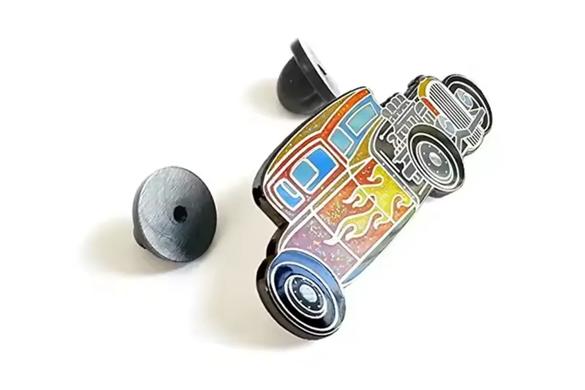 Small colorful vehicle pin with a dark reverse and detached rubber clutch.