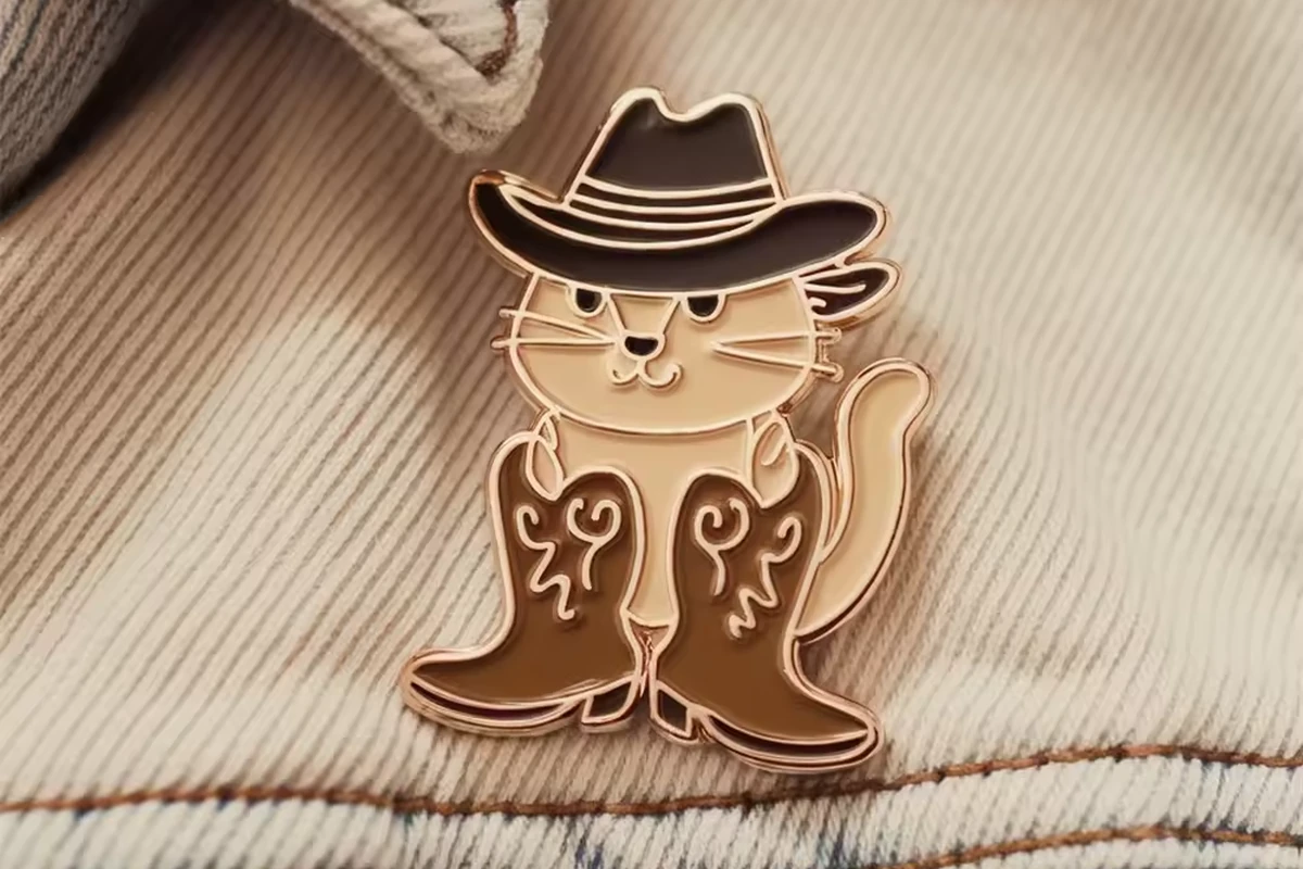 A cowboy cat pin on fabric.