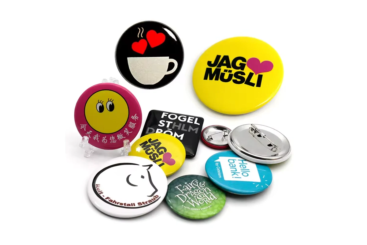 Brightly colored printed round badges with two silver pin-backs.