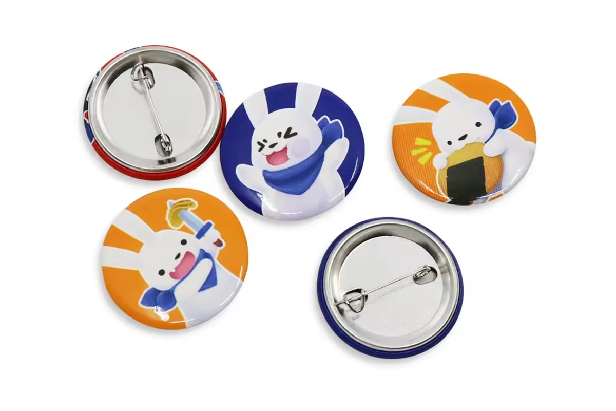 Colorful cartoon round badges with silver safety-pin backs.