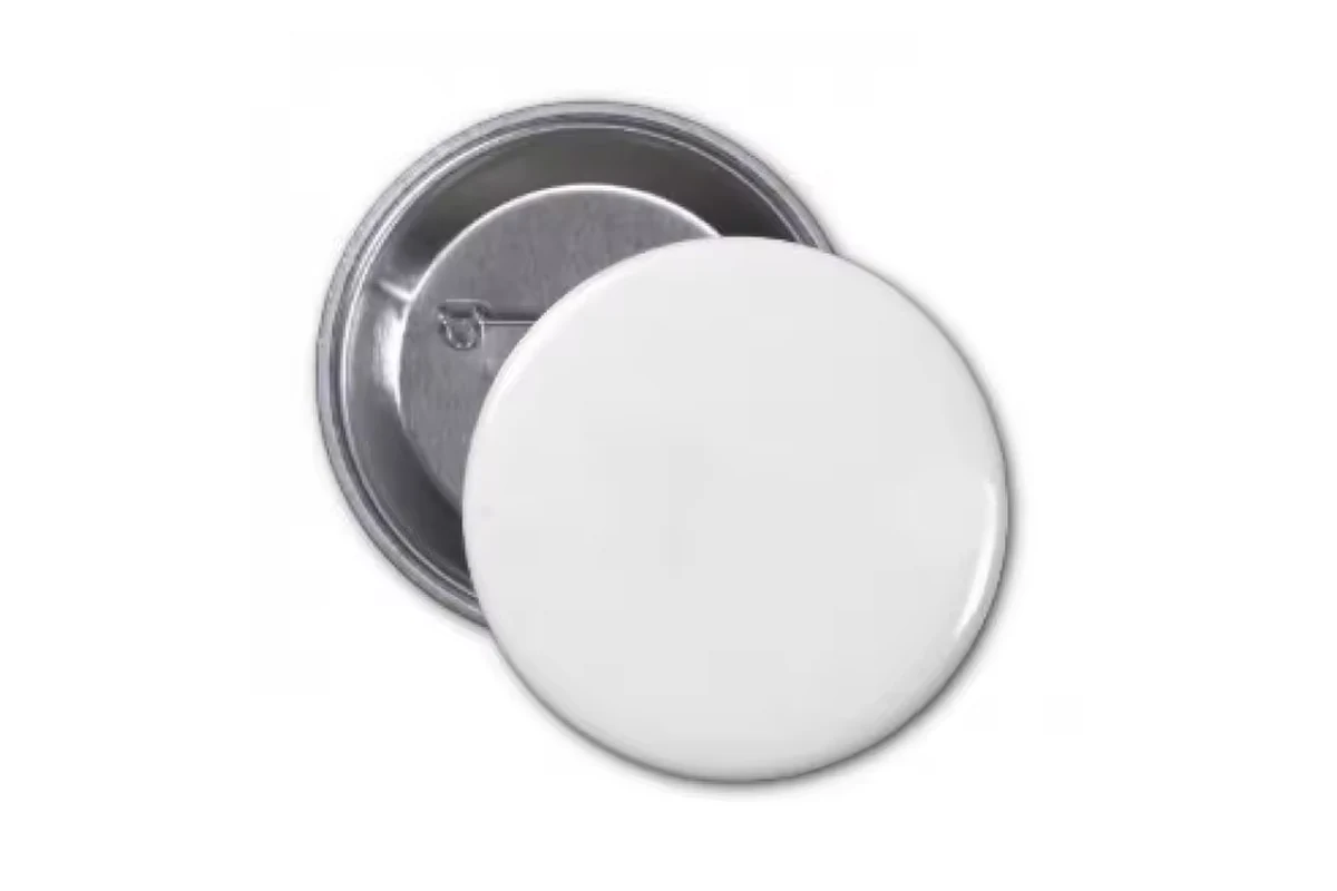 Plain white round badge in front of a silver pin-back badge.