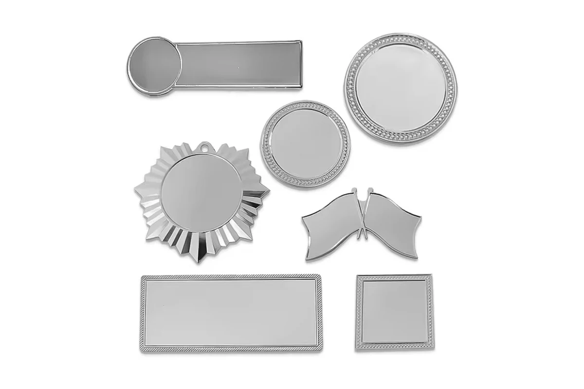 Assorted silver blank pin shapes, including round, sunburst, shield, rectangle and square.