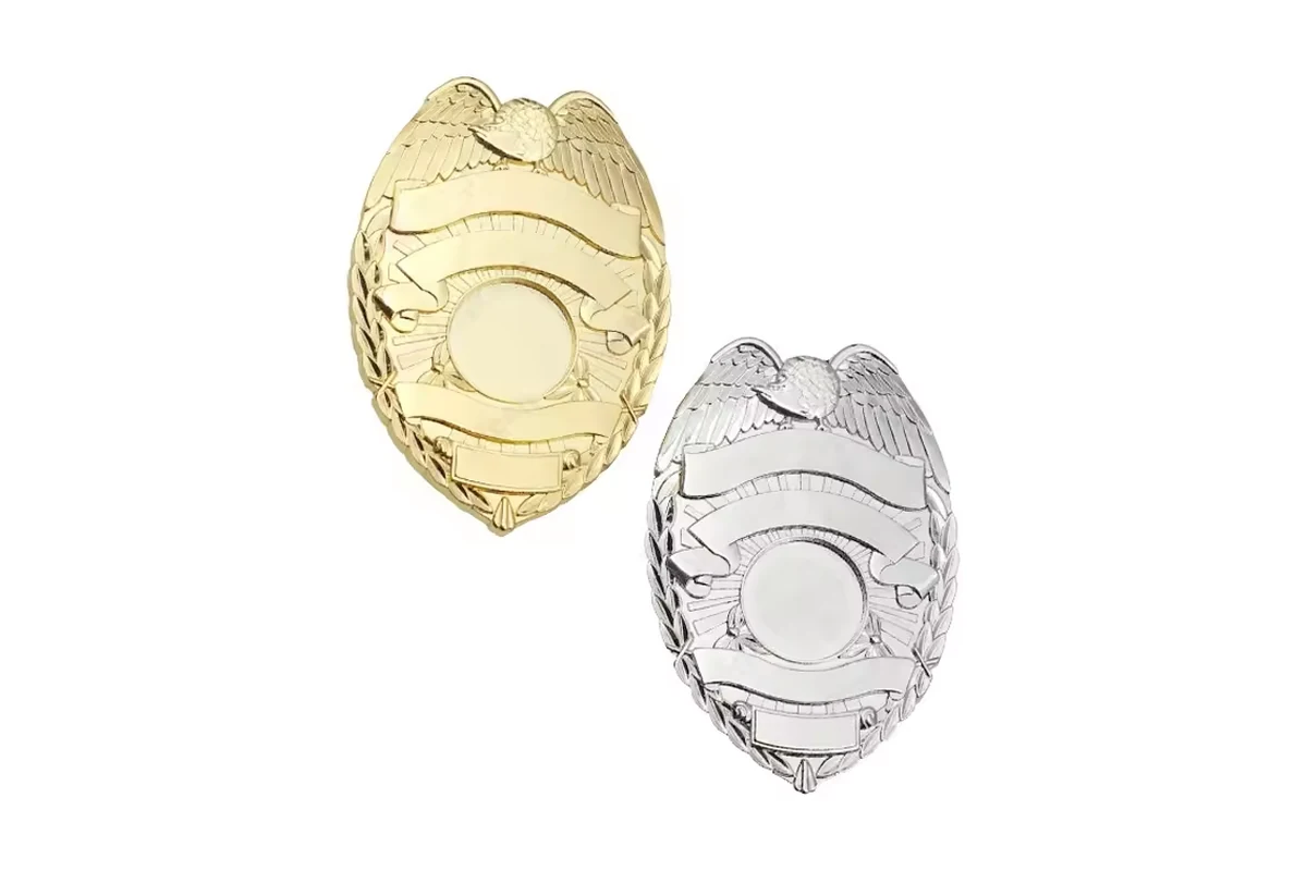 Gold and silver unfilled shield badge fronts on white.