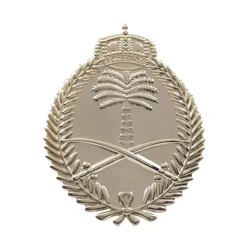 Silver unfilled embossed Saudi-style emblem with palm tree and crossed swords.