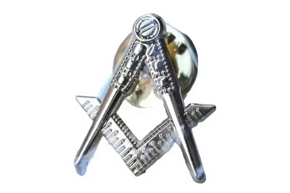 Silver compass-and-square fraternal lapel pin with textured metal details.
