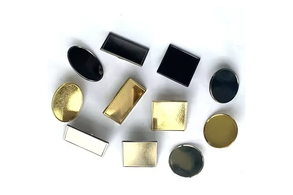 Small geometric blank metal settings and dark inserts in round, oval, square and rectangular shapes.