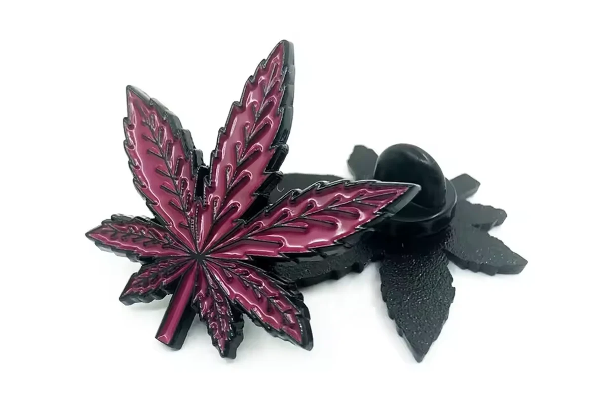 A red leaf pin with a black rubber clutch.