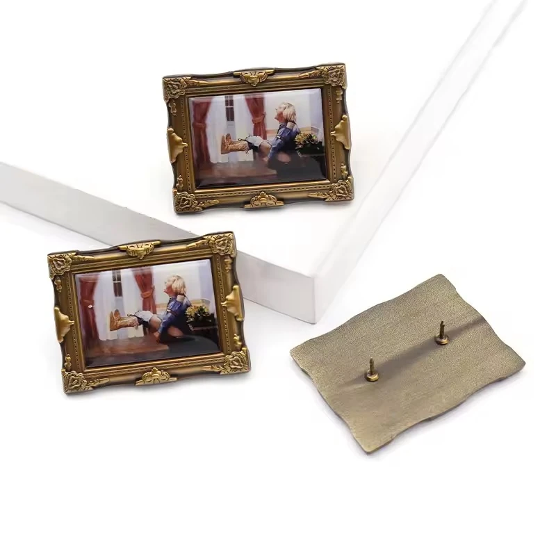 Small antique gold picture-frame pins containing a full-color photograph, shown with metal backs.
