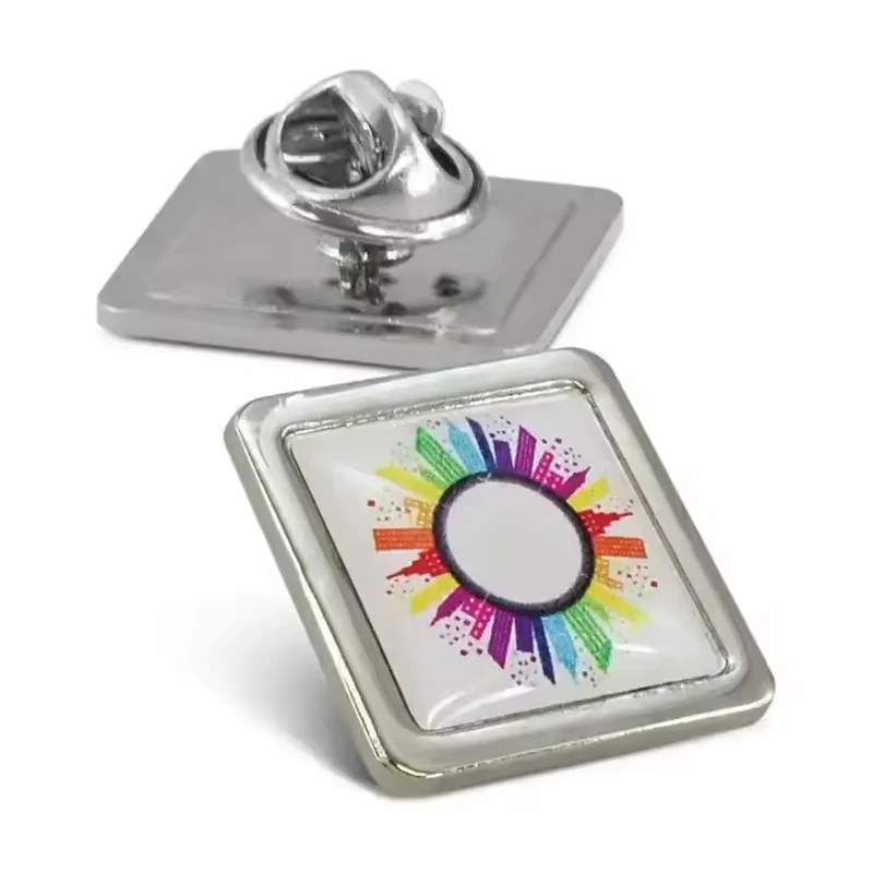 A silver square pin with a colorful circular graphic beside its reverse and butterfly clutch.