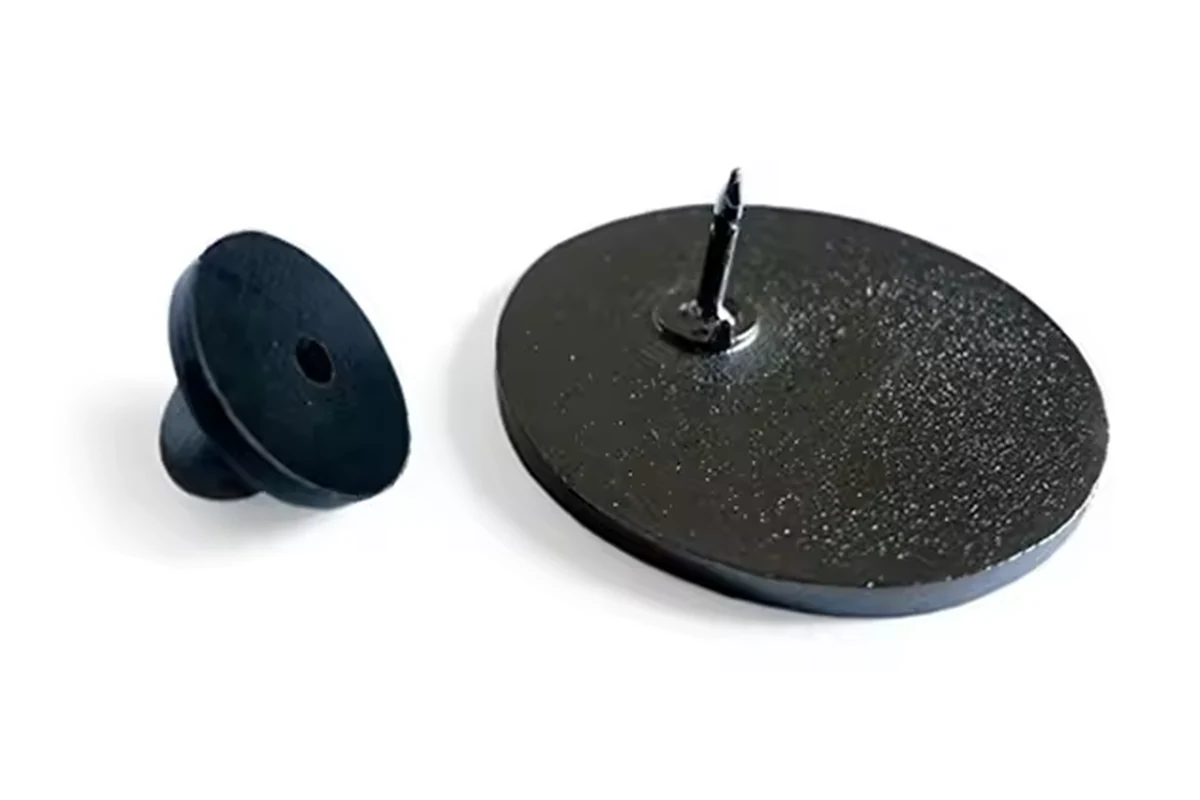 A plain dark round pin back with one central post and a separate black rubber clutch.
