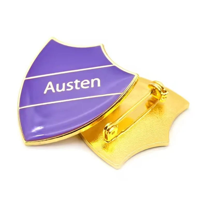 A purple Austen shield badge shown with its gold safety-pin reverse.