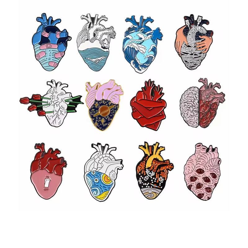 Twelve anatomical heart-themed pins featuring bandages, ocean waves, hands, roses, a starry planet, a brain-and-heart design, a switch, art patterns and eyes on a white background.