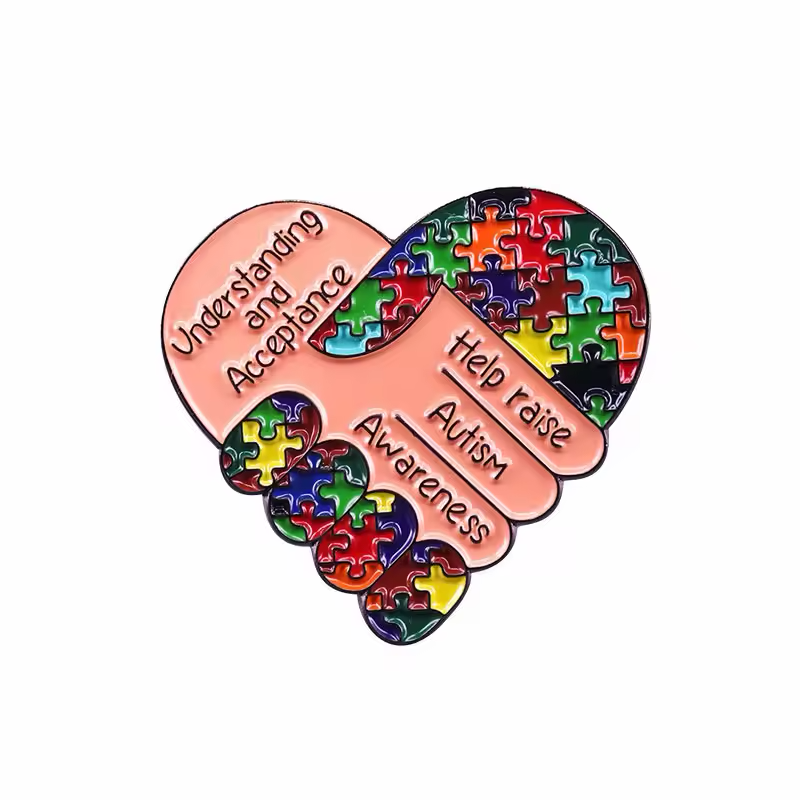 Heart-shaped handshake pin with multicolored puzzle pieces and autism awareness lettering.