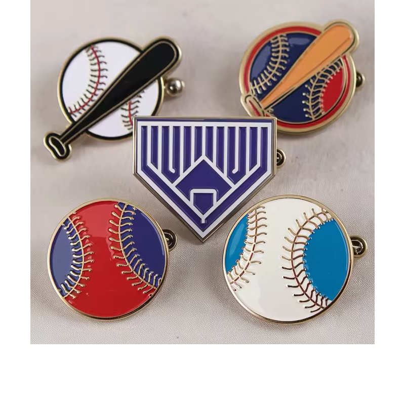 Five baseball-themed pins on pale fabric, including two ball-and-bat designs, two round baseballs and a purple home-plate emblem.