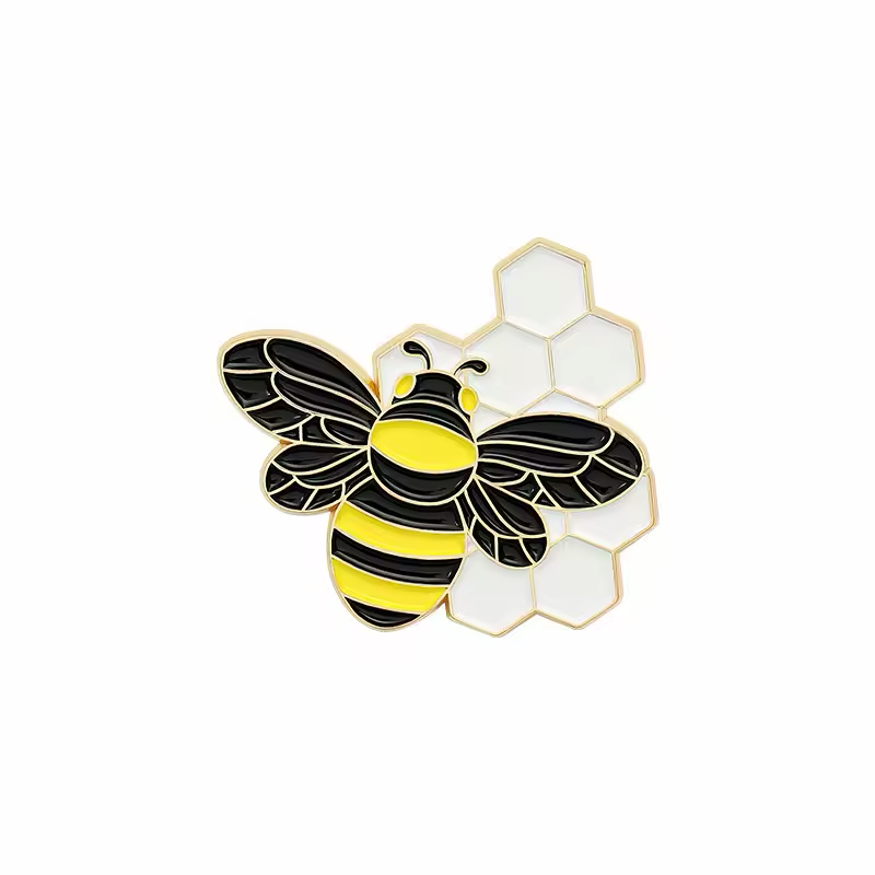 Black and yellow bee pin over white honeycomb cells.