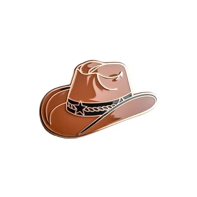 Brown cowboy hat pin with a curved brim, a dark hatband with a star and chain-like decoration, and gold-tone outlines on a white background.