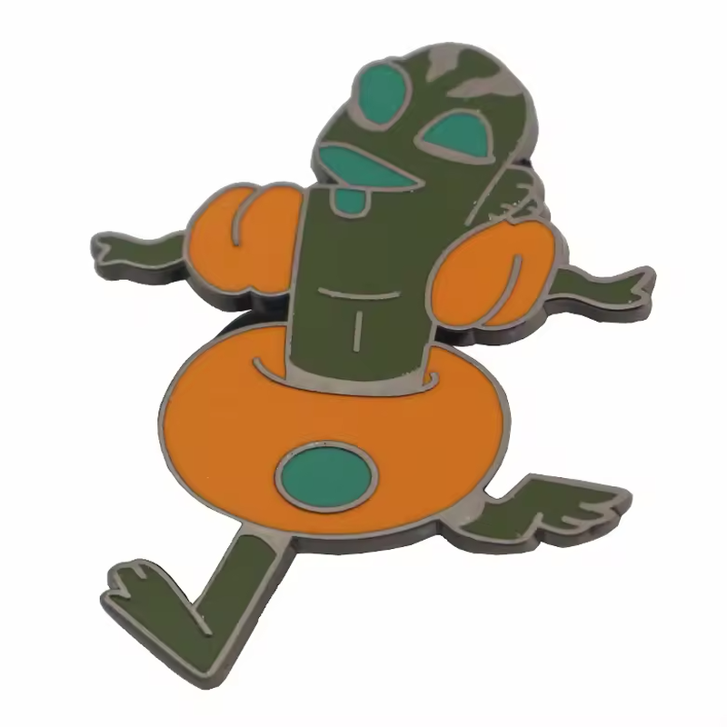 Green pickle-shaped cartoon character pin wearing orange arm floats and a swim ring.