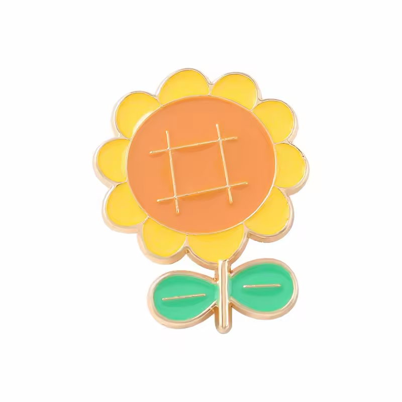 Cartoon sunflower pin with yellow petals, an orange center and two green leaves.