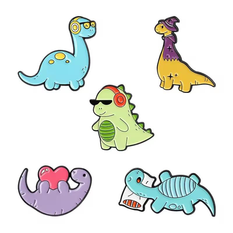 Five colorful cartoon dinosaur pins with headphones, a wizard hat, a heart and a pillow.