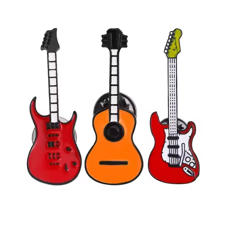 Three guitar pins: two red electric guitars and an orange acoustic guitar.