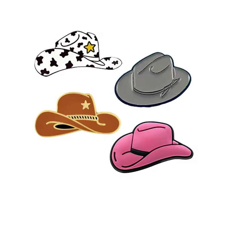 Four cowboy hat pins in white with black cow-print patches and a yellow star, gray, brown with a gold-tone star, and pink with a black hatband on a white background.