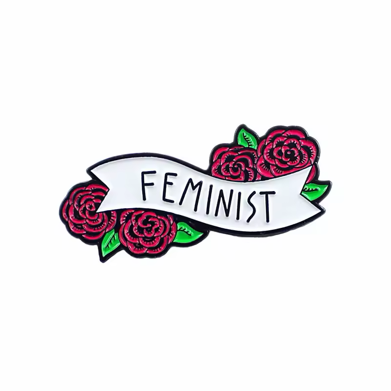 White FEMINIST banner pin framed by red roses and green leaves.