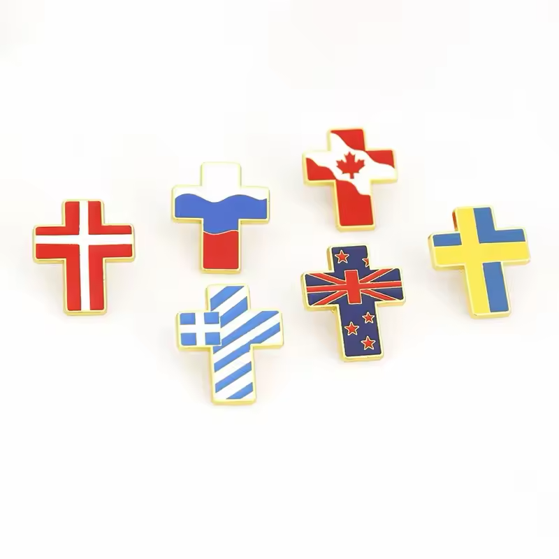 Six cross-shaped pins decorated with national flag colors and gold-colored outlines.