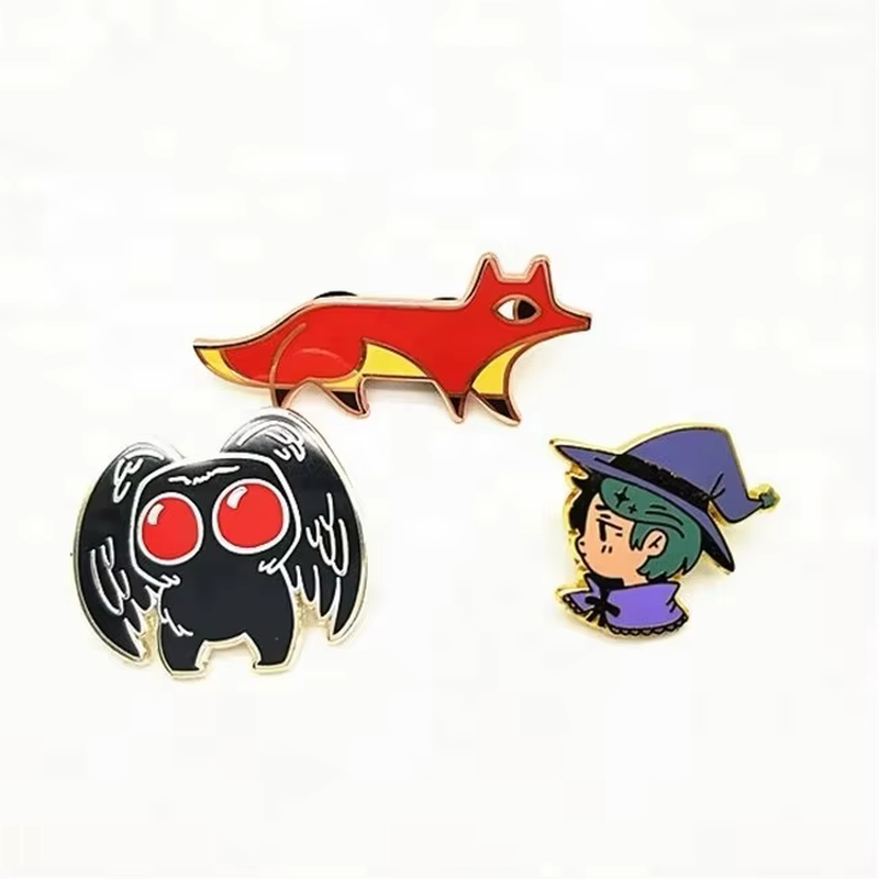Three fantasy pins featuring a red fox, a black winged creature with red eyes and a witch portrait in a purple hat.