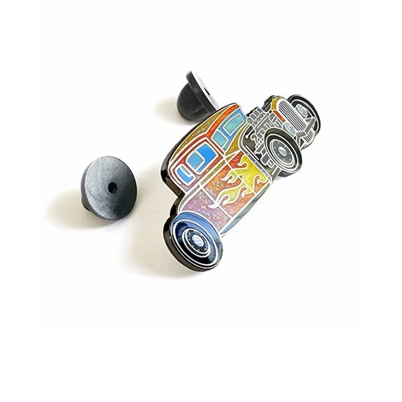 Angled view of an orange and gold glitter hot rod car pin with flame graphics and two black rubber clutches on a white background.