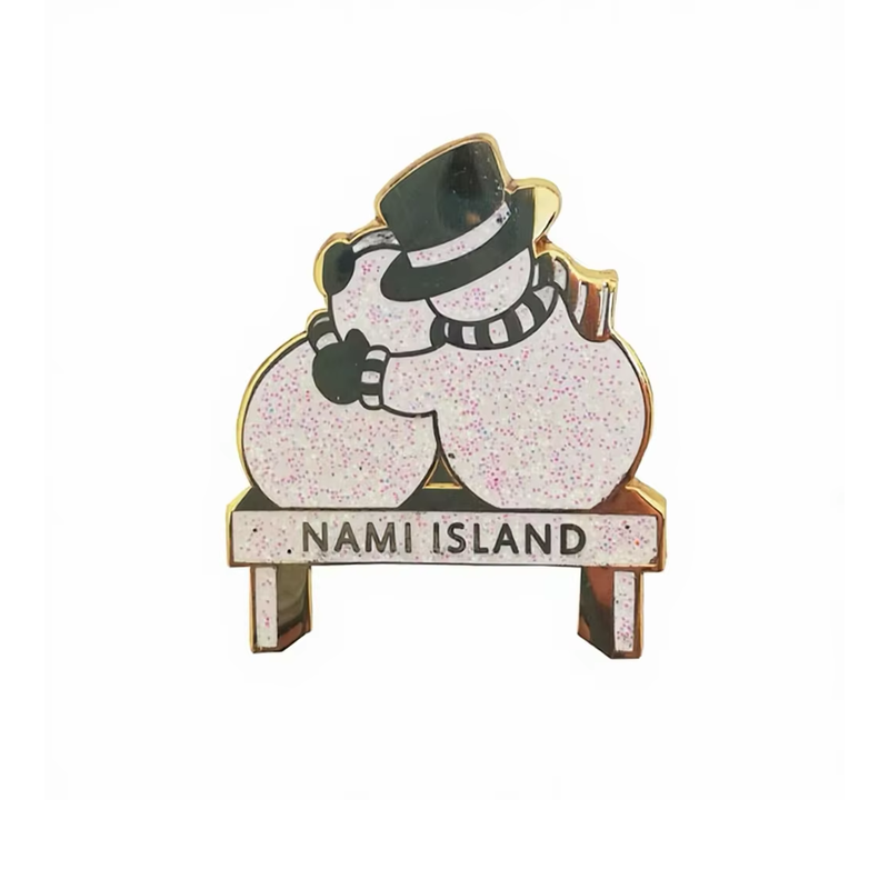 Glitter snowman couple pin on a bench marked Nami Island, with a black top hat and striped scarf.
