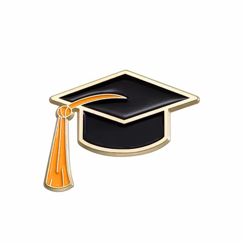 Black graduation cap pin with an orange tassel and gold-colored outlines.