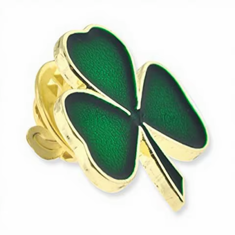 Green shamrock pin with a gold-colored border and butterfly clutch.