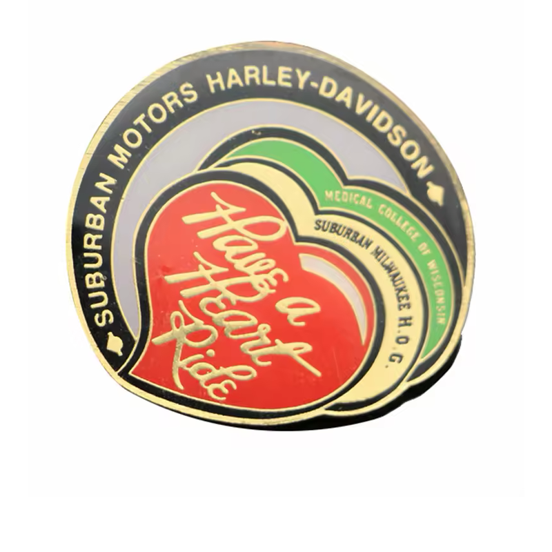 Ride event pin with overlapping red, yellow and green hearts, a black outer border and gold-tone Have a Heart Ride lettering.