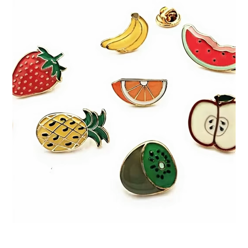 Fruit pin assortment with strawberry, bananas, watermelon, orange, pineapple, apple and kiwi designs; some designs are partially outside the original photo edges.
