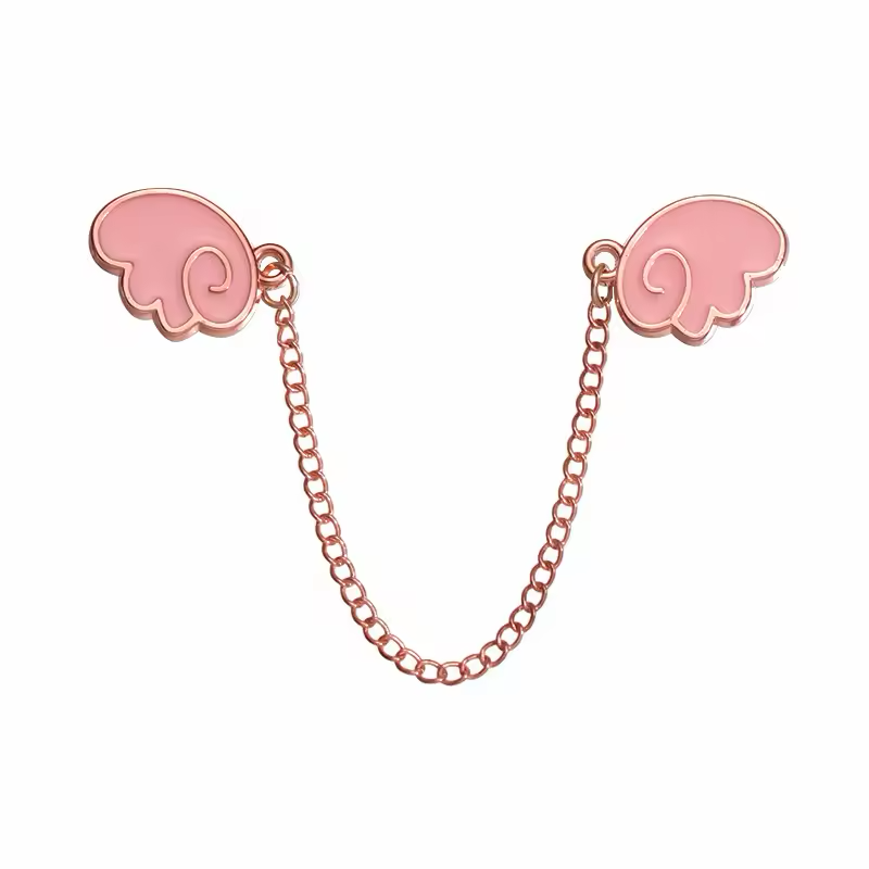 Two pink wing-shaped pins with rose-gold-tone outlines joined by a hanging chain on a white background.