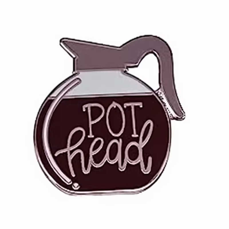 Coffee carafe pin with a gray handle and lid, dark brown coffee and the words POT head on a white background.