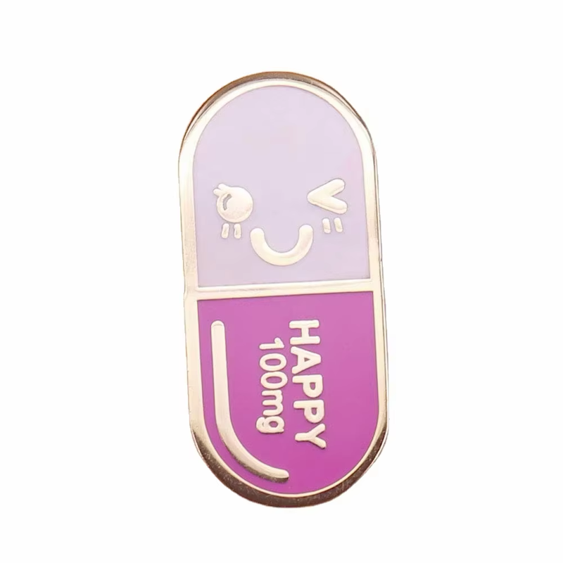 Purple and pink capsule-shaped pin with a winking smiling face, HAPPY 100mg lettering and gold-tone outlines on a white background.