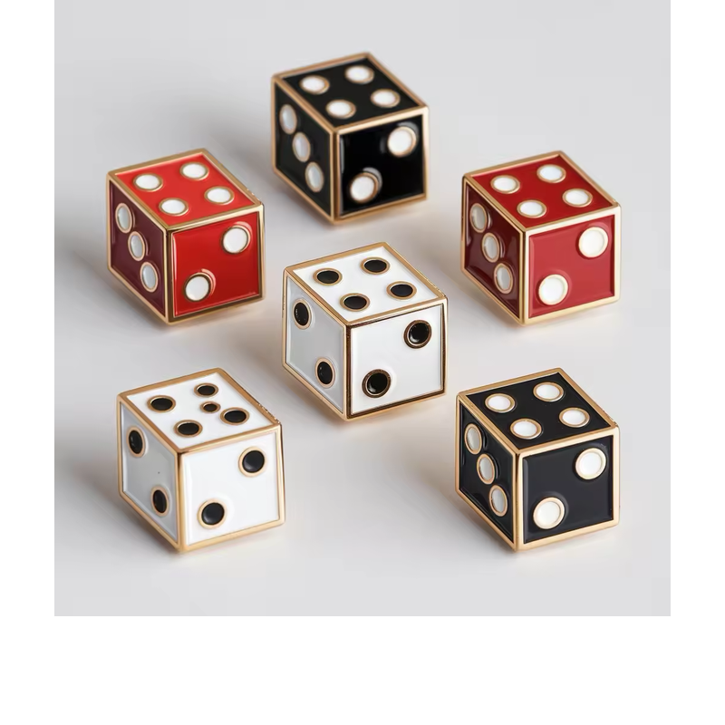 Six cube-style dice pins in red, white and black with contrasting dots and gold-tone outlines, arranged on a light gray background.