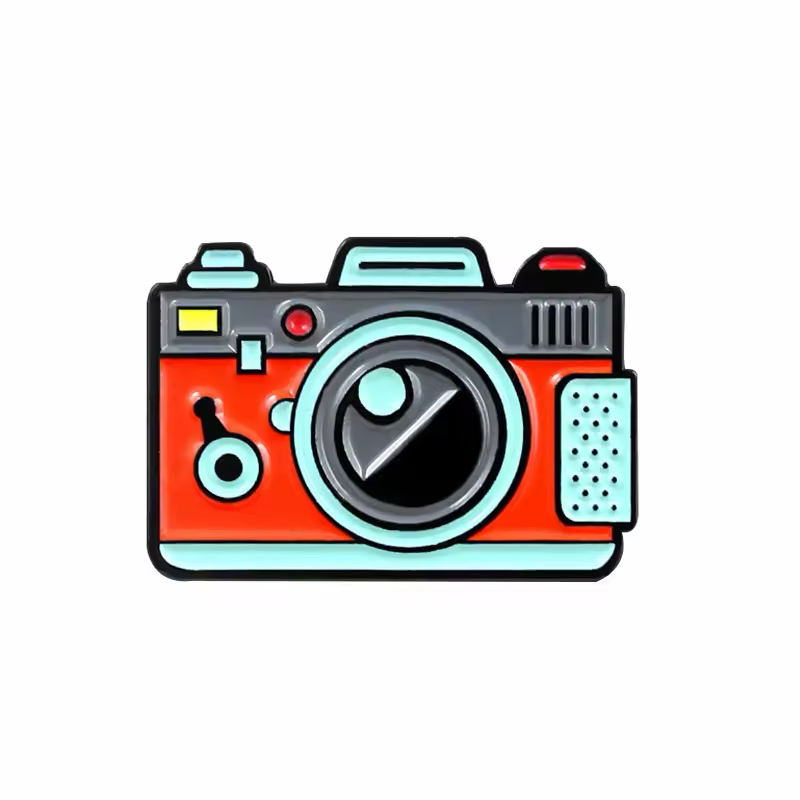 Retro camera pin with a red body, gray top and turquoise lens ring and trim.