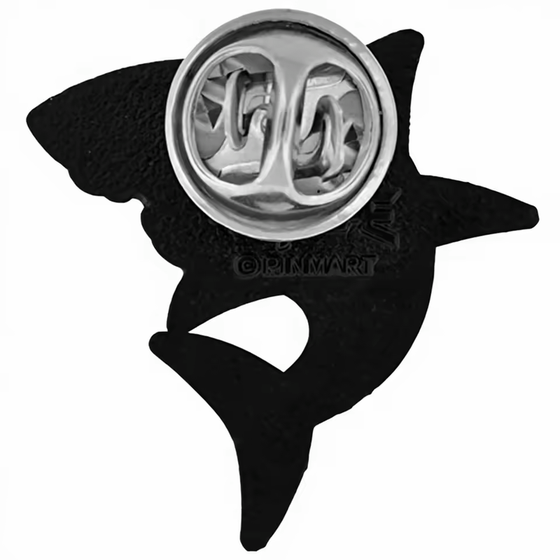 Black reverse of a shark-shaped pin with a silver-tone butterfly clutch, textured surface and embossed lettering on a white background.