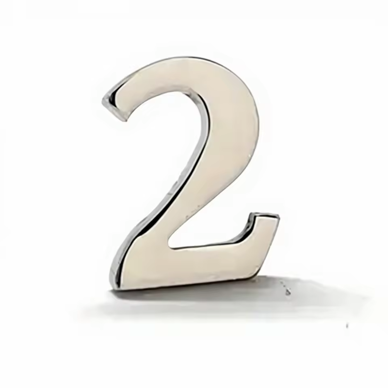 Silver-tone number 2 pin with a smooth reflective face and visible metal edges, standing upright with a shadow on a white background.