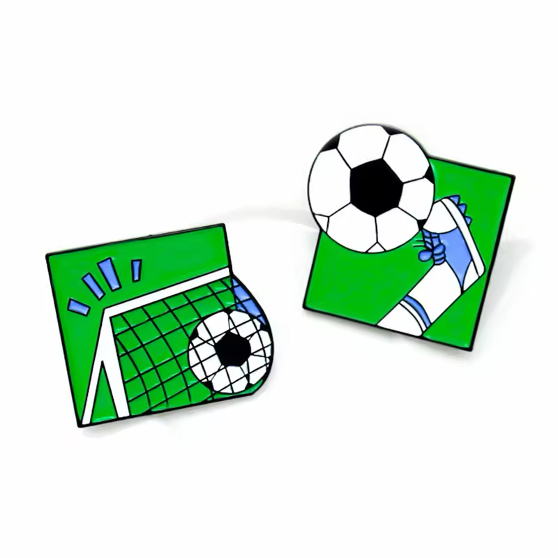 Two green soccer pins showing a ball entering a goal net and a cleat kicking a ball.