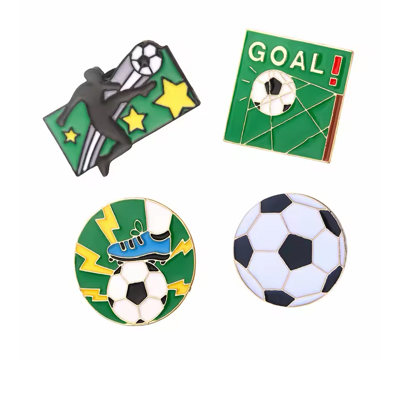 Four soccer pins featuring a kicking player, a GOAL design, a cleat on a ball and a black-and-white soccer ball.