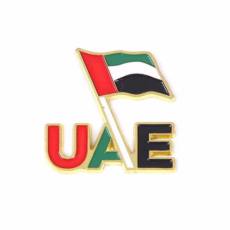 UAE flag pin above red, green and black UAE letters, with gold-colored outlines.