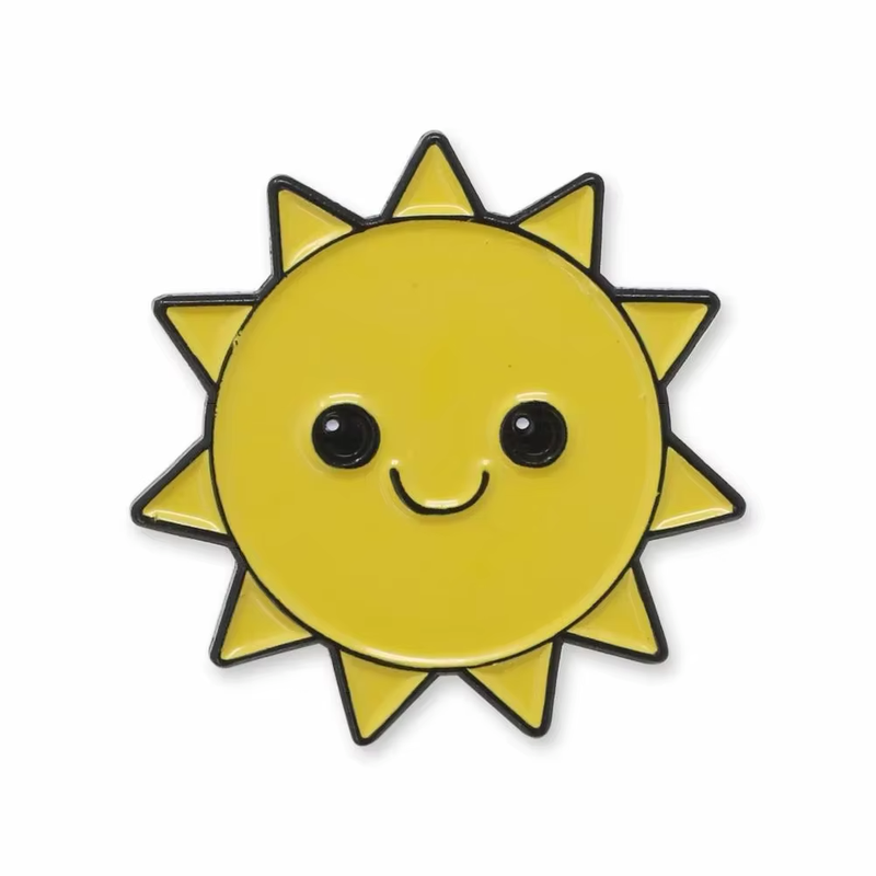 Yellow smiling sun pin with black outlines, round black eyes and triangular rays on a white background.