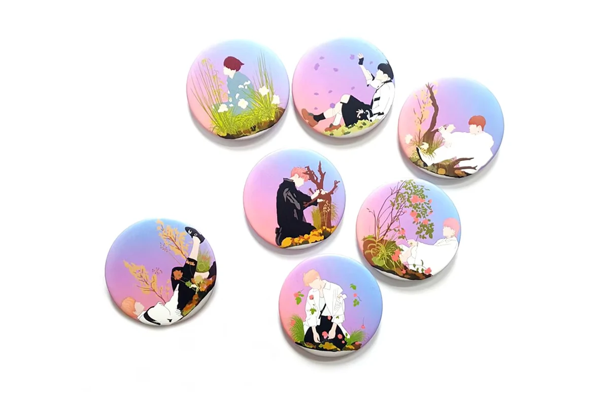 Seven round badges printed with pastel character illustrations.