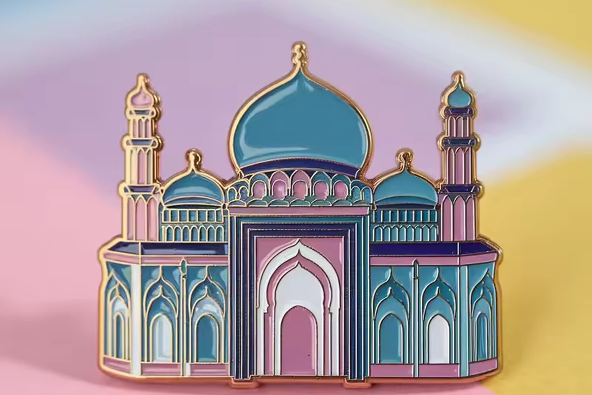 A blue, pink and gold-colored architectural enamel pin on a pastel background.
