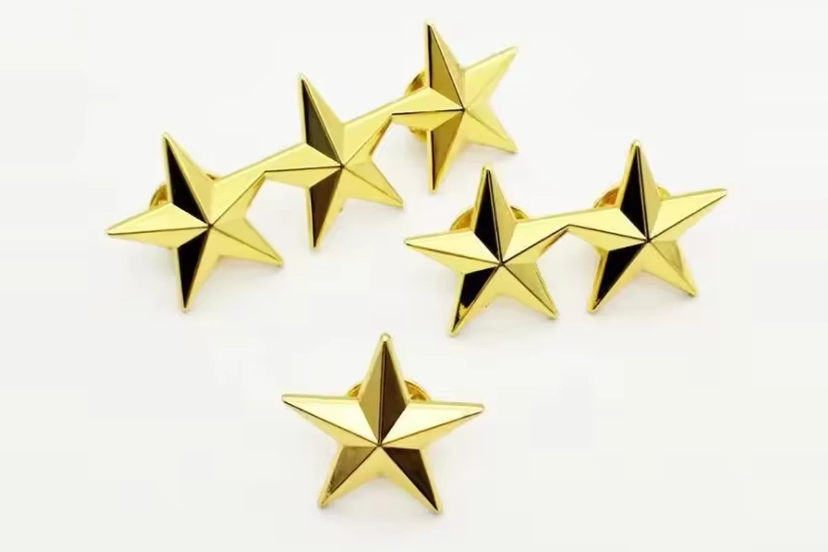 Six matching gold-tone five-point star pins arranged on a pale background.