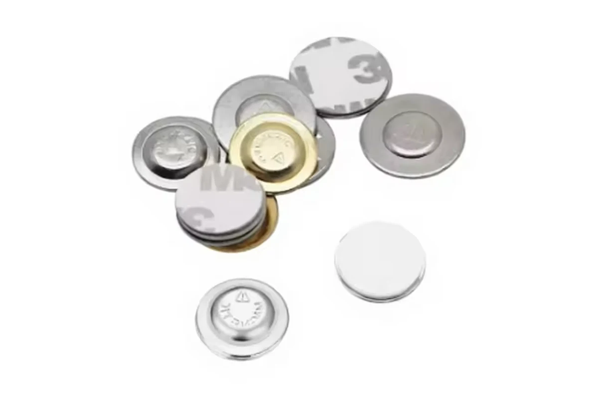 Round silver badge components with separate circular pads and adhesive-backed pieces.